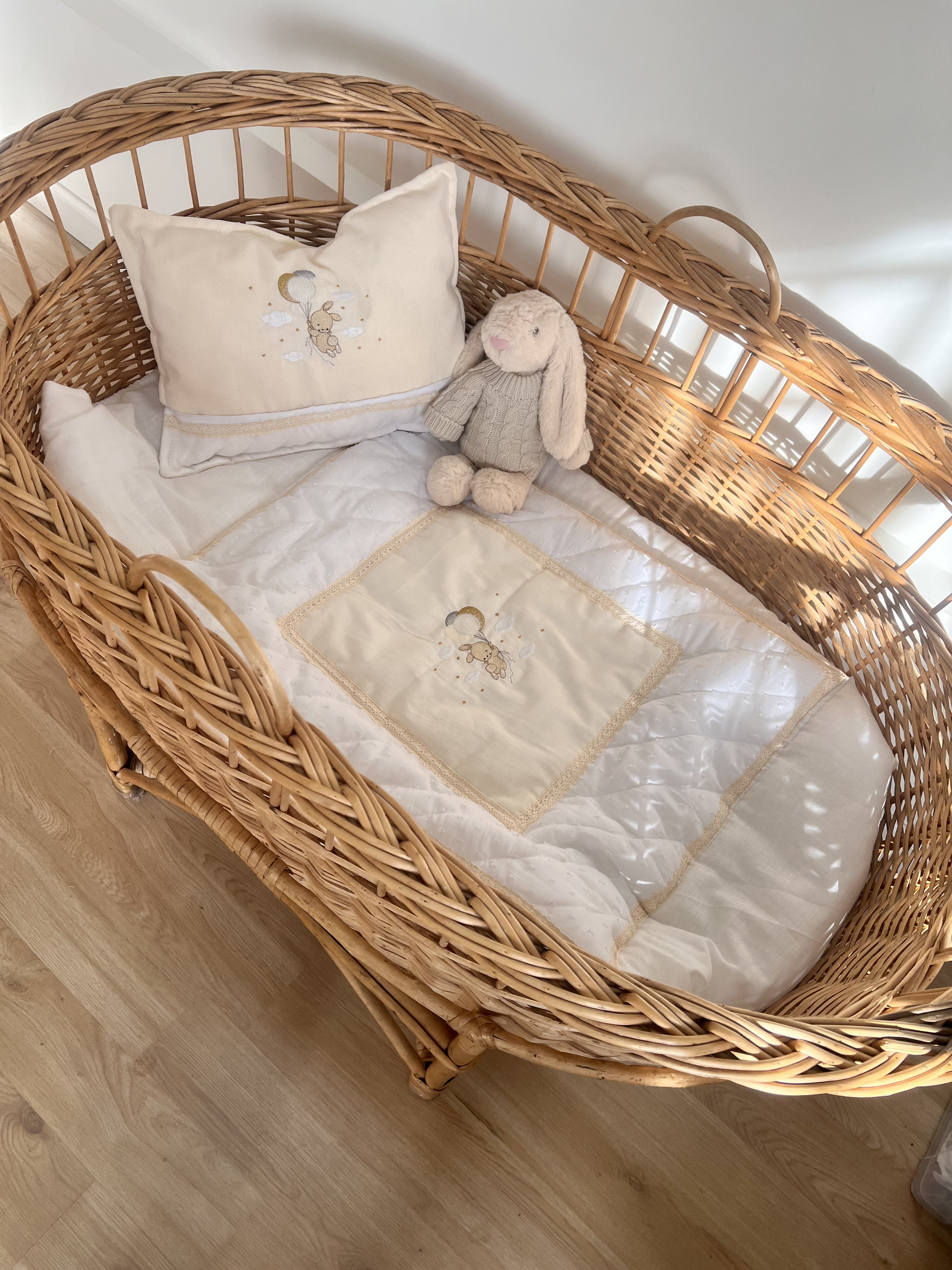 Acolchado con almohada a juego en cuna de mimbre